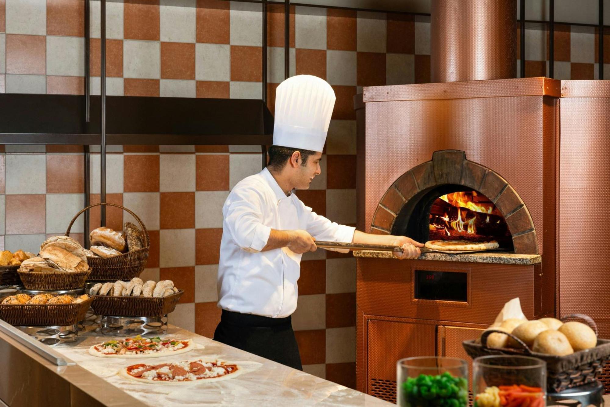 Ajman Saray, A Luxury Collection Resort, Adzsmán Kültér fotó A pizzaiolo making a pizza